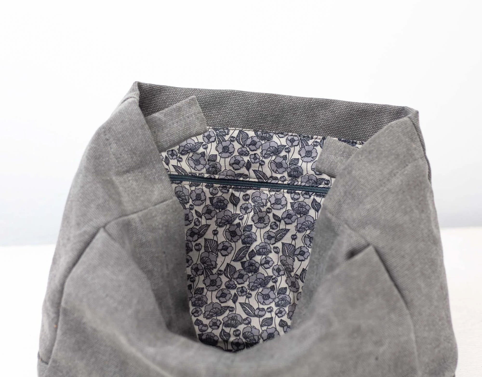 Gray fabric with a floral patterned pocket on a white background