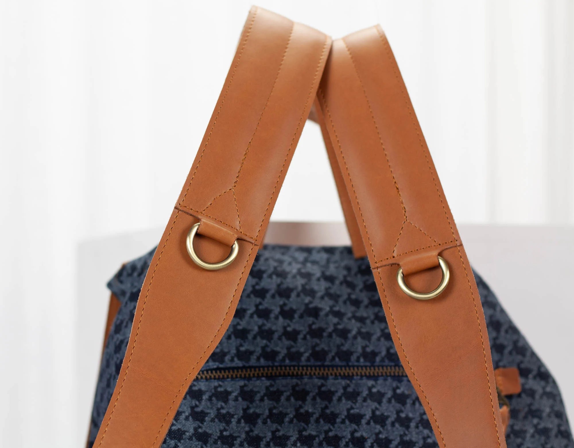 Backpack with brown leather straps on a white background