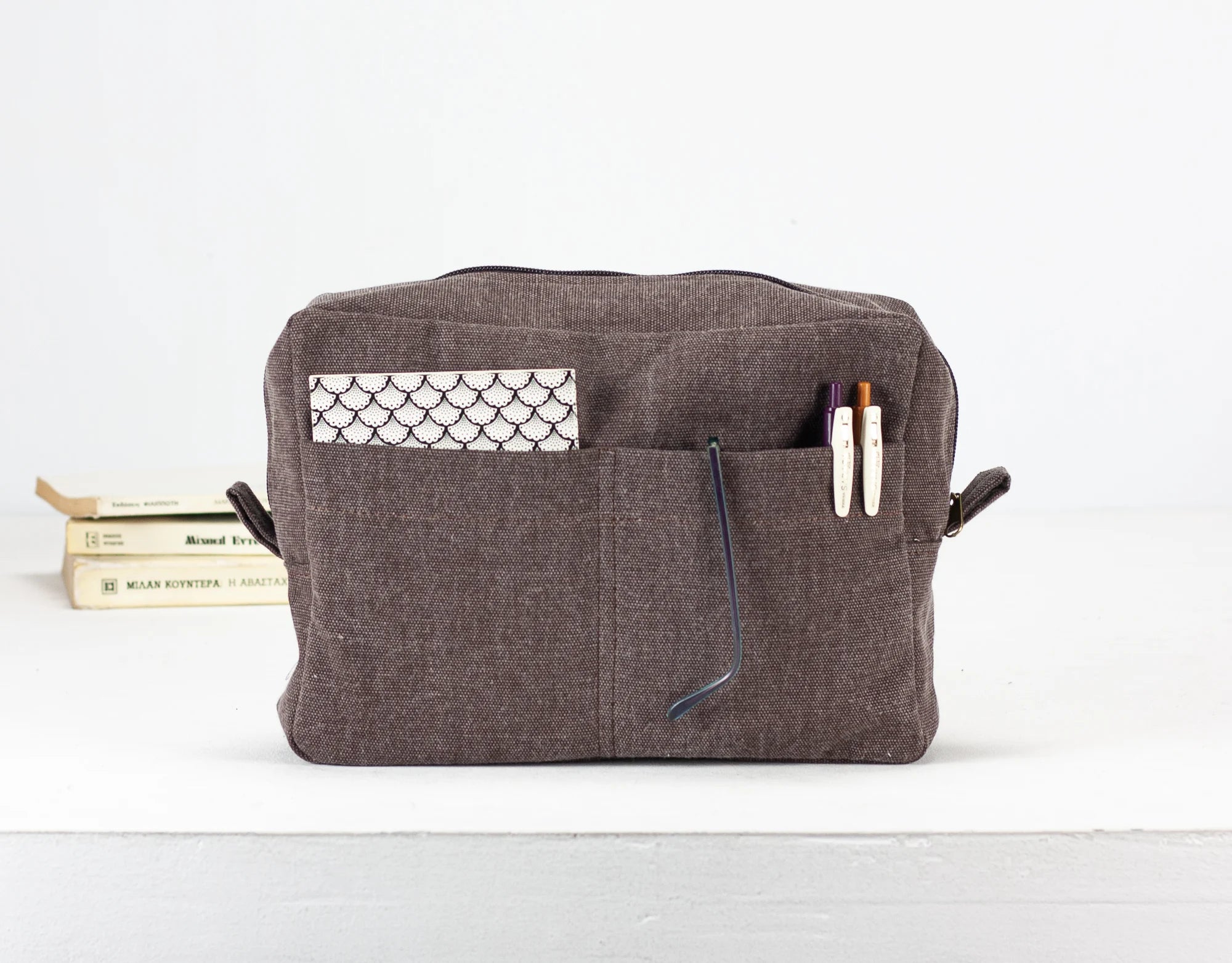 Brown toiletry bag with pockets on a white background