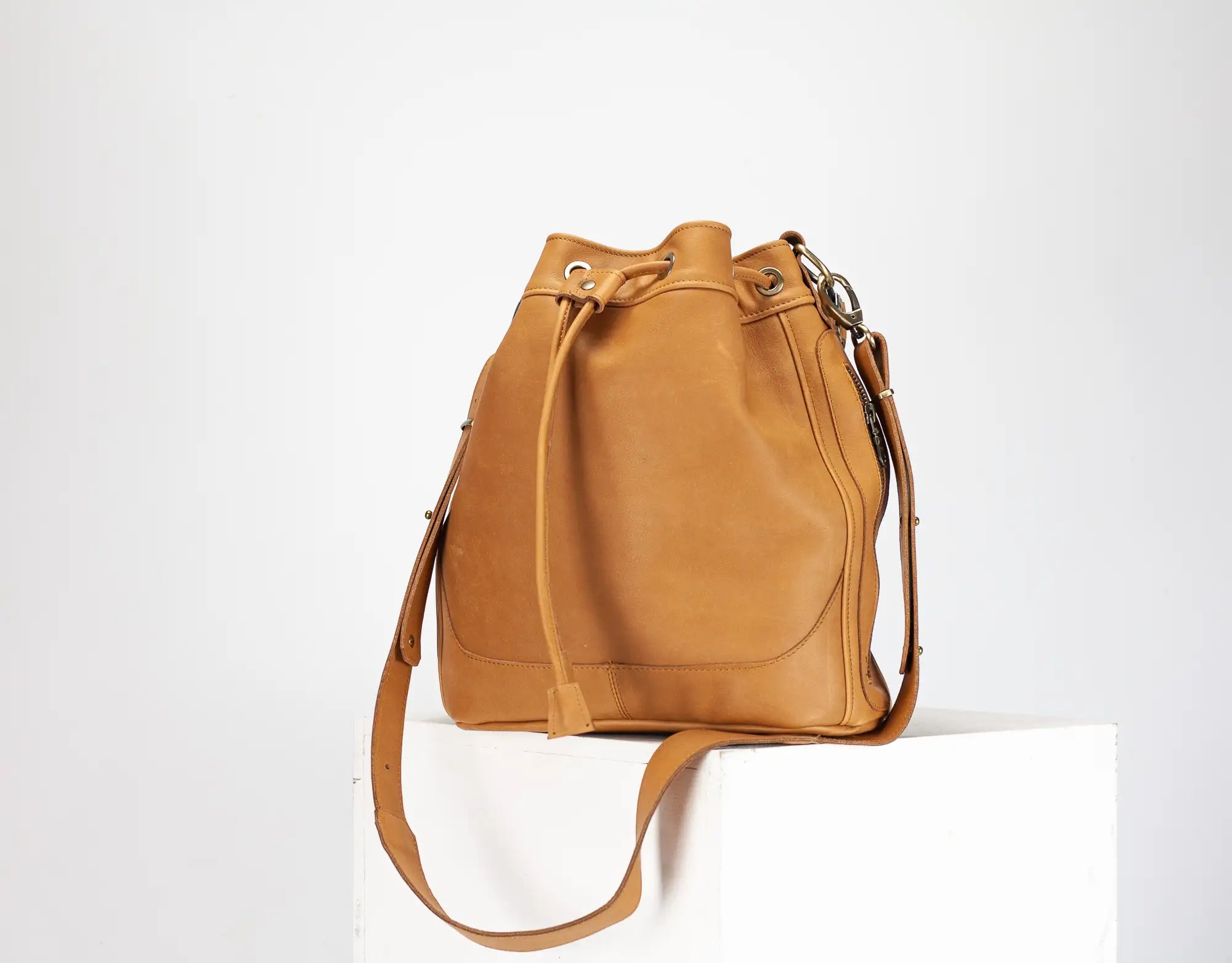 Tan leather bucket bag on a white background