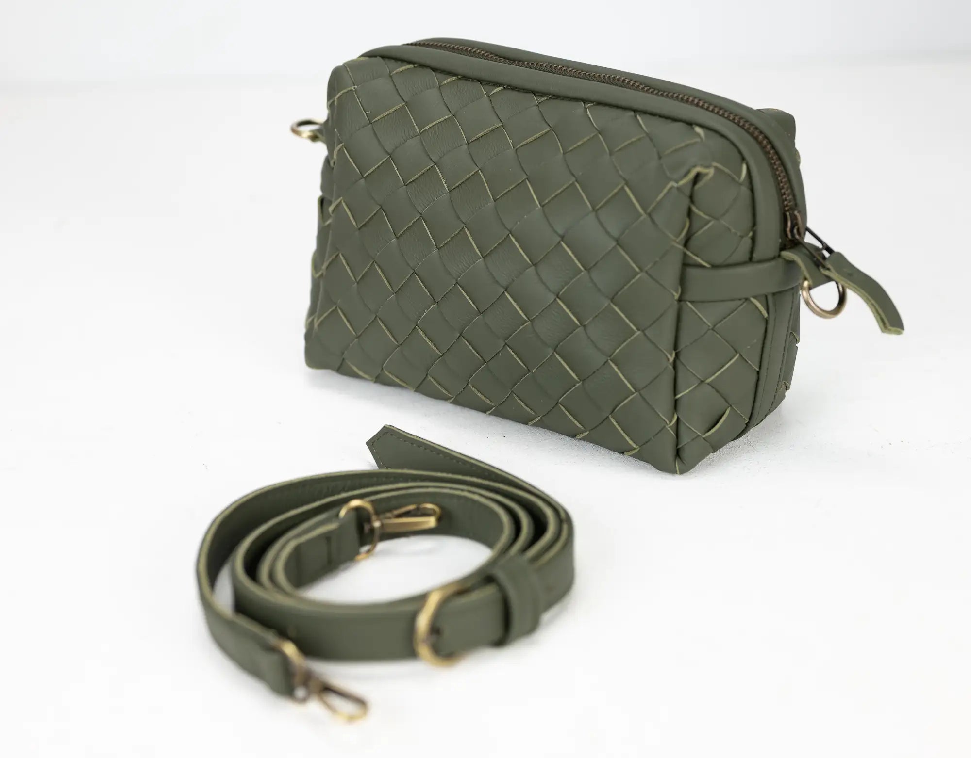 Green woven handbag with a detachable strap on a white background