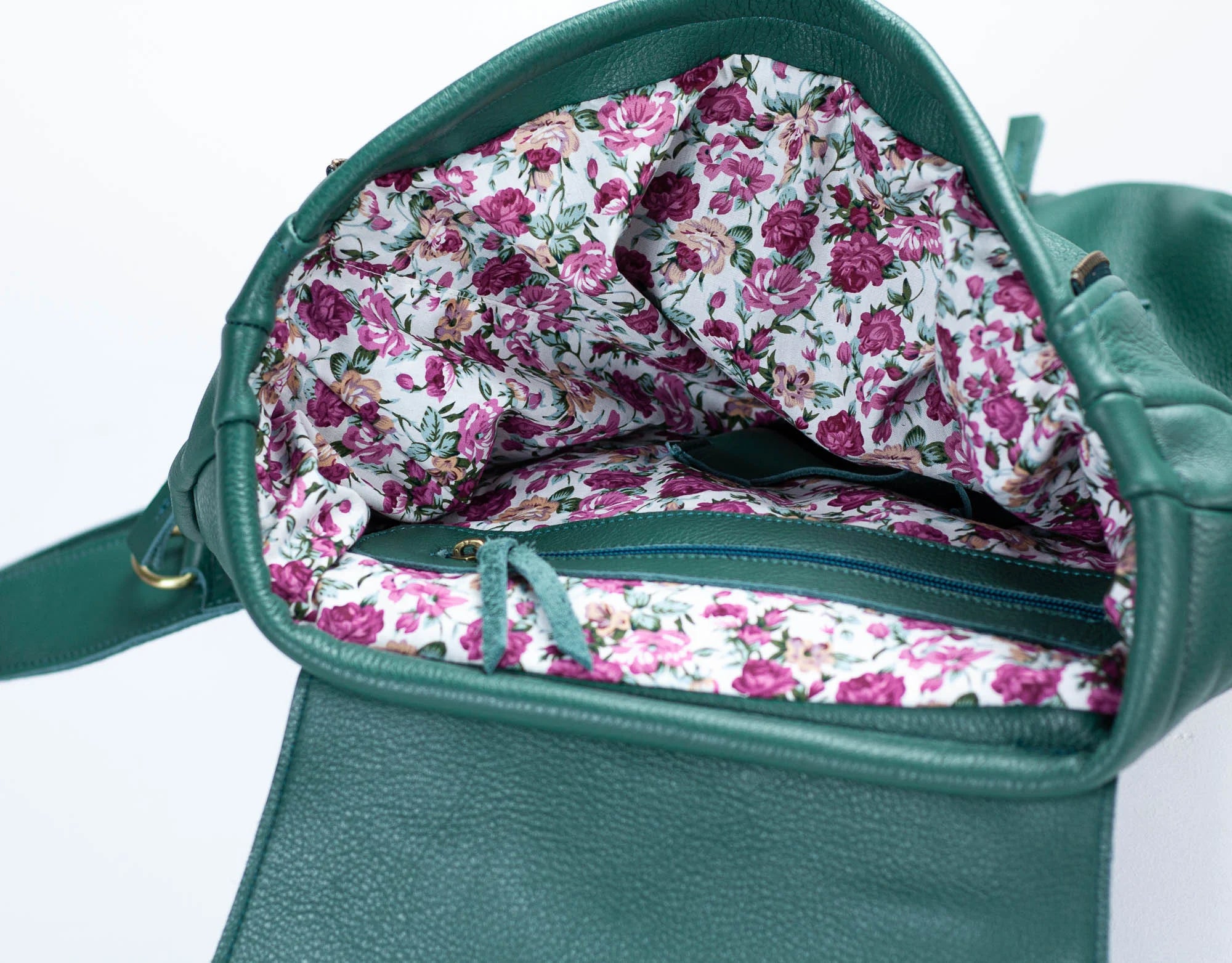 Green handbag with floral lining on a white background
