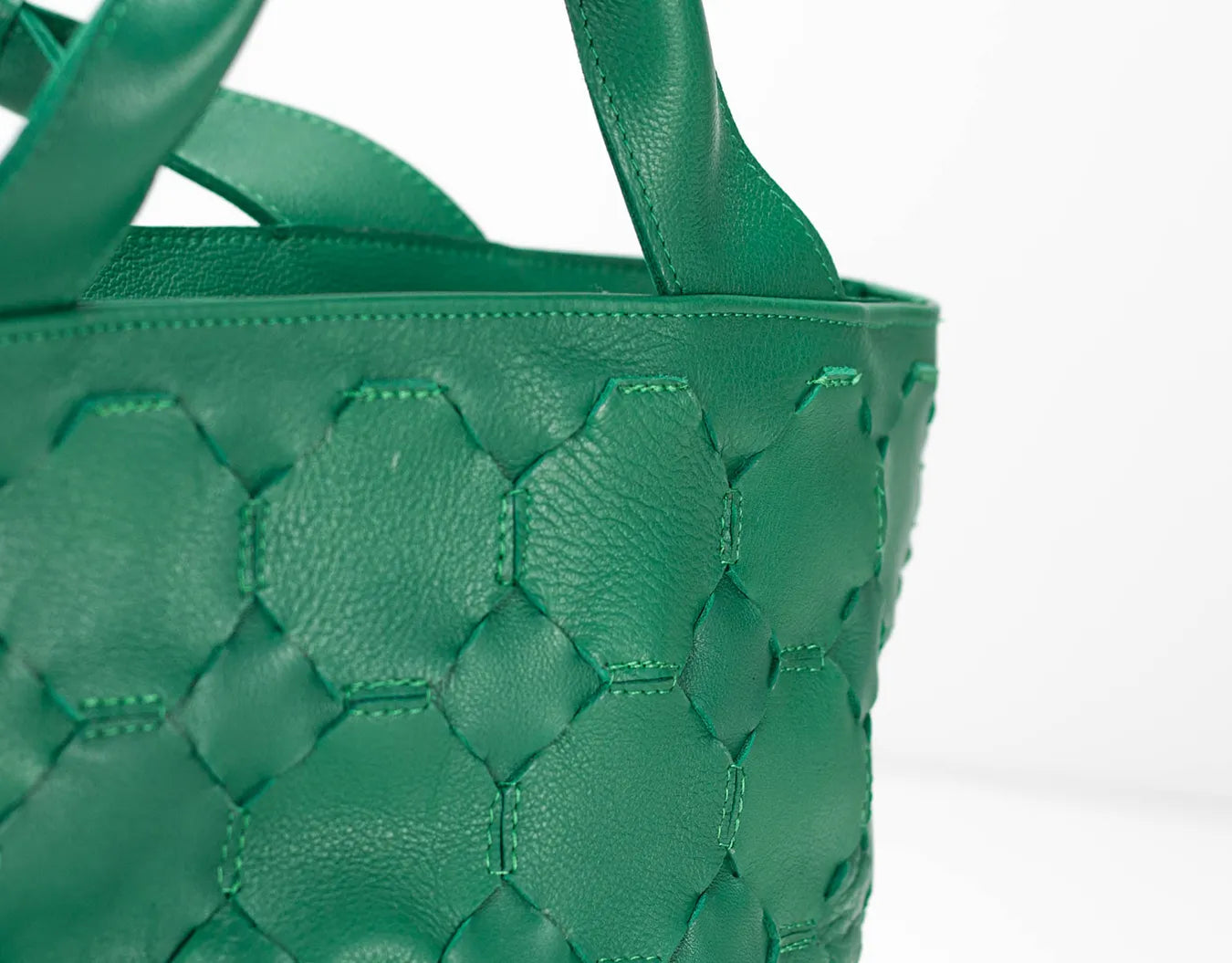 Green woven handbag on a white background