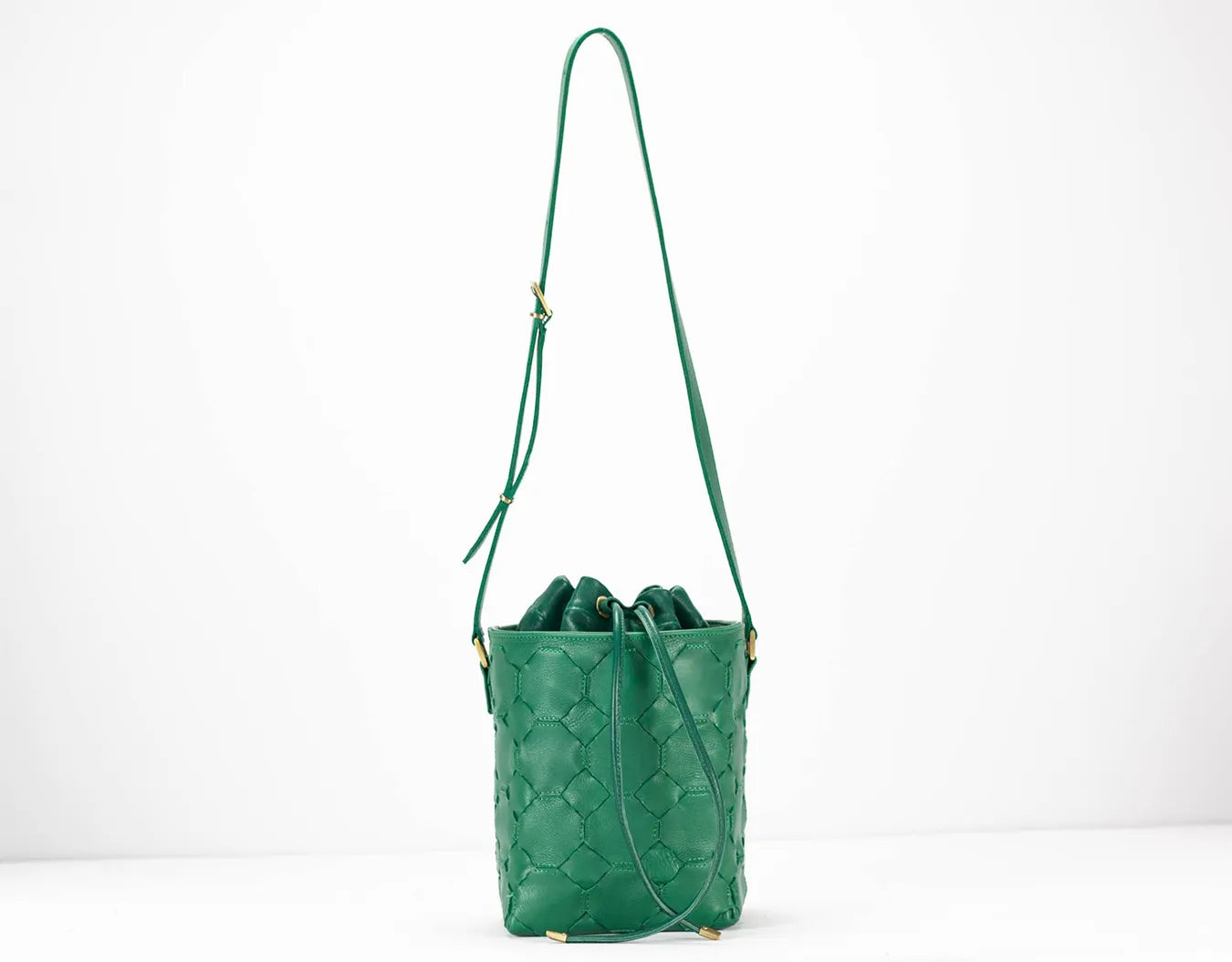 Green quilted handbag with a strap on a white background