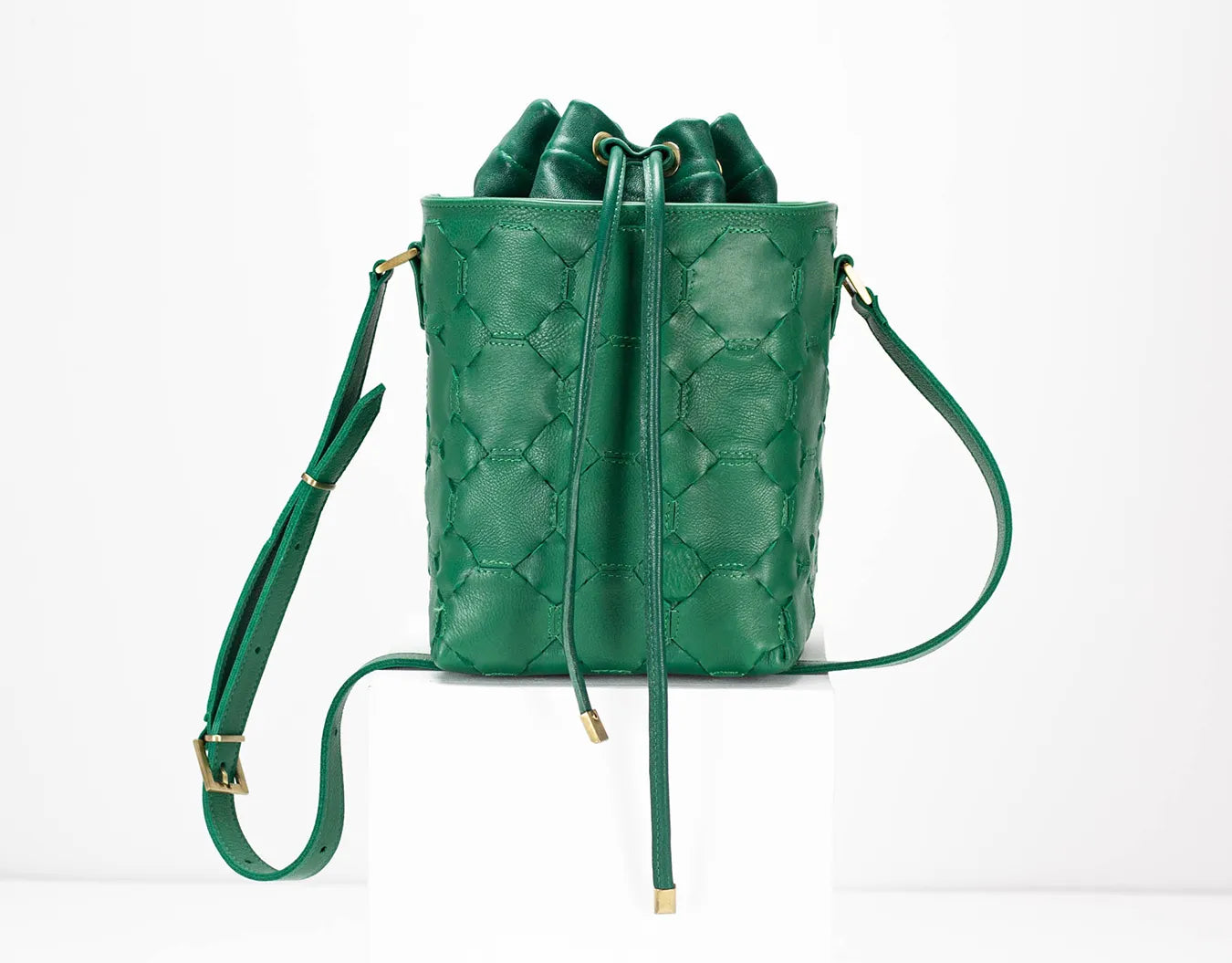 Green leather backpack with quilted pattern on a white background