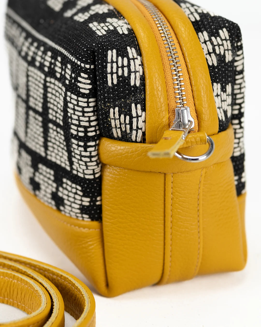 Yellow handbag with black and white patterned strap