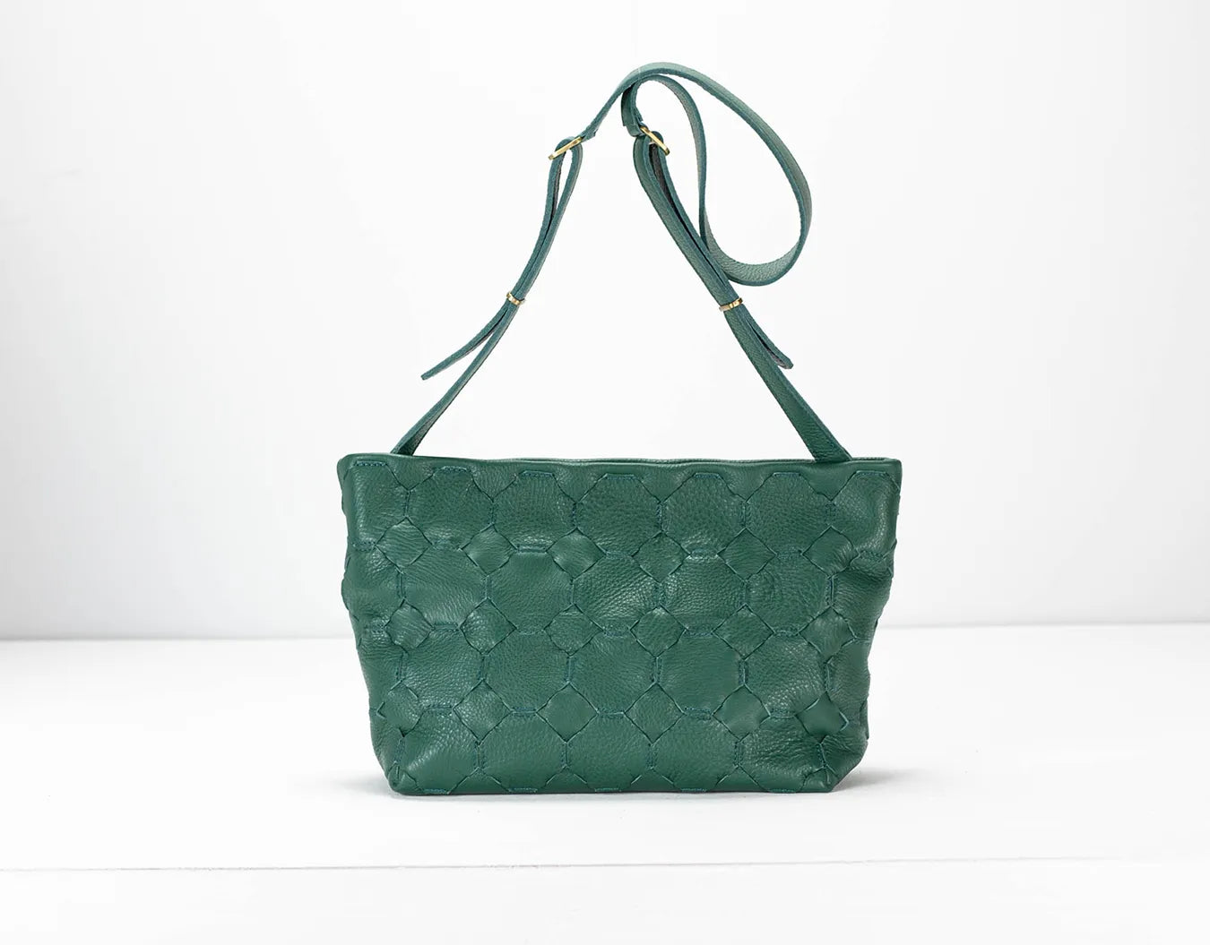 Green textured handbag with a strap on a white background