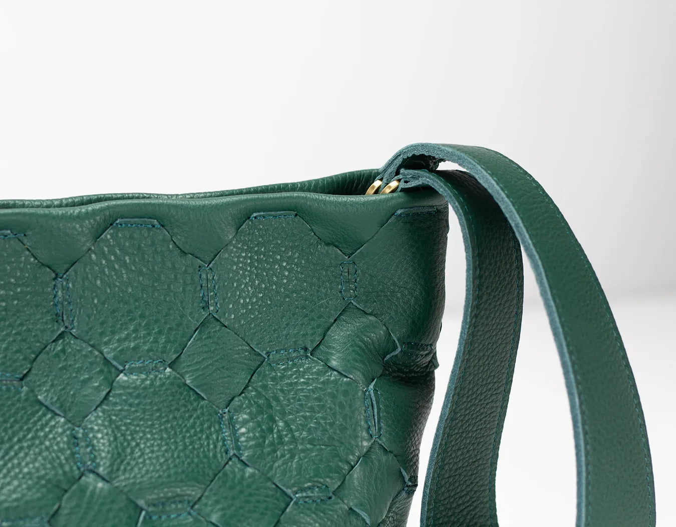 Green woven handbag with a strap on a white background