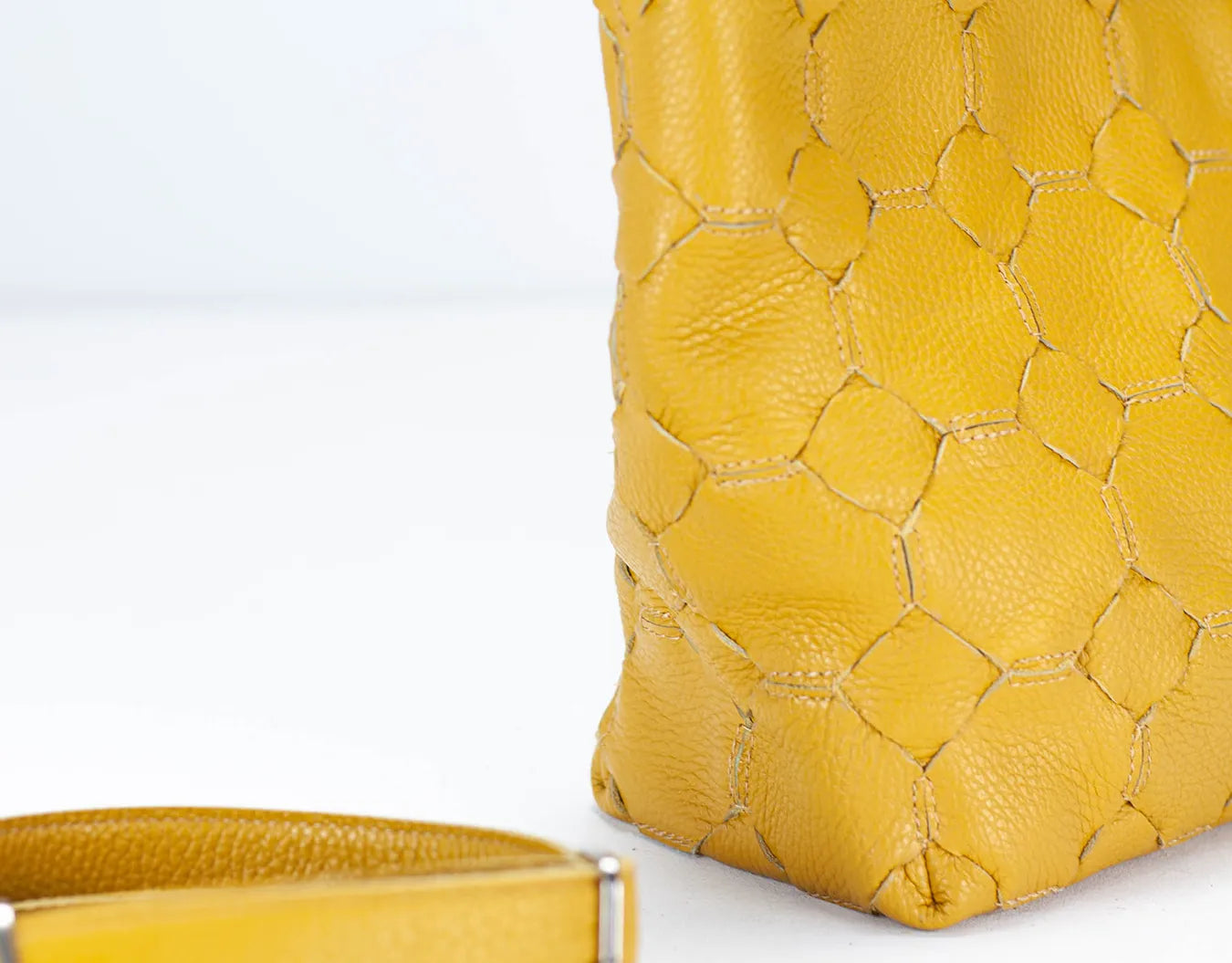 Yellow textured handbag on a light gray background