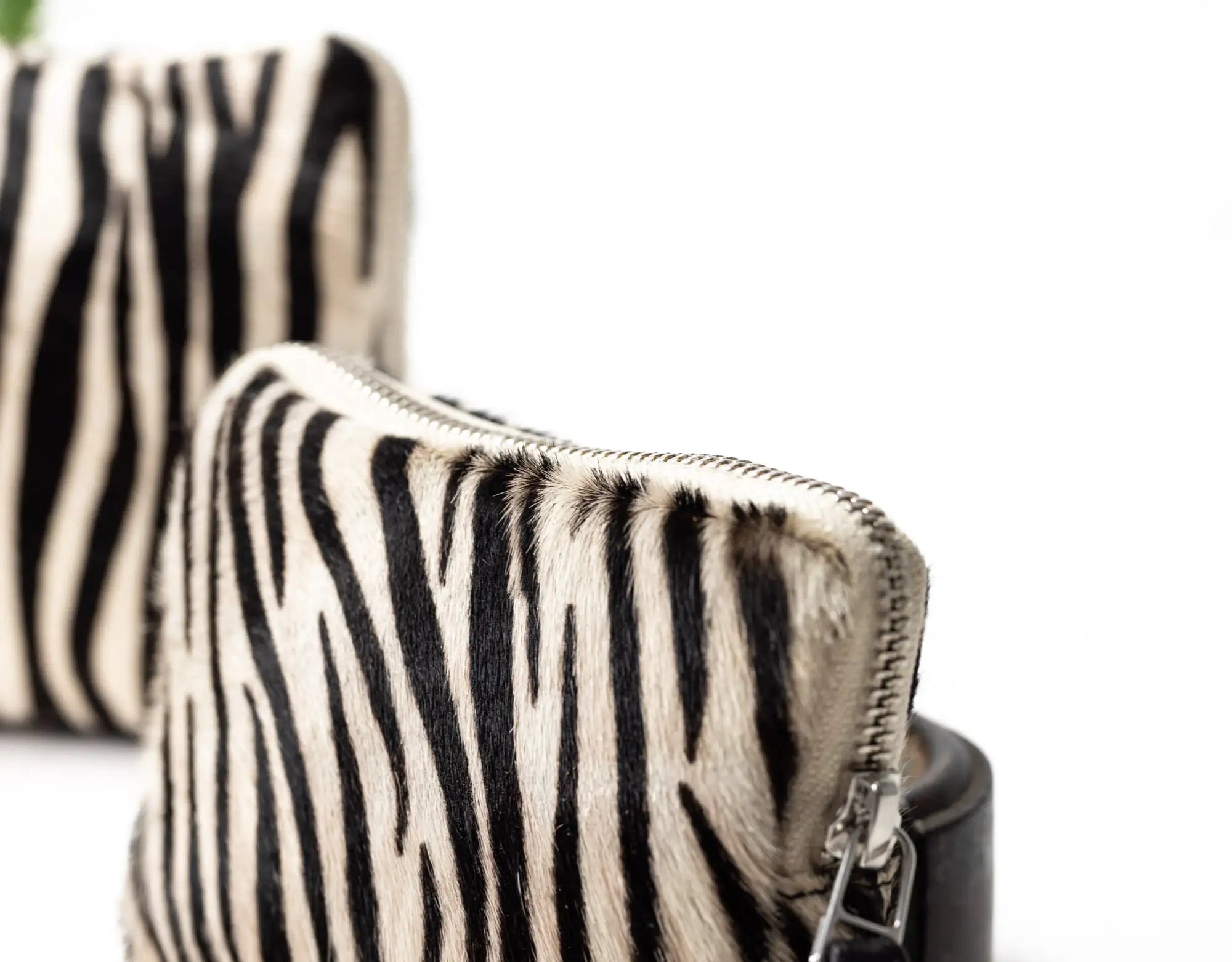 Zebra-patterned handbag with a visible zipper on a white background