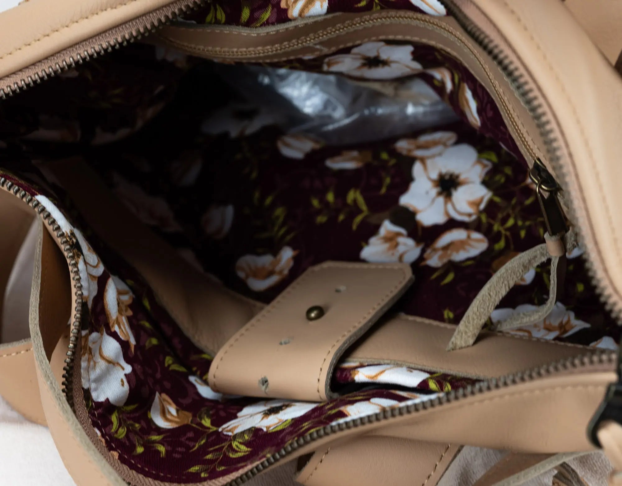 Close-up of a beige handbag with floral interior lining