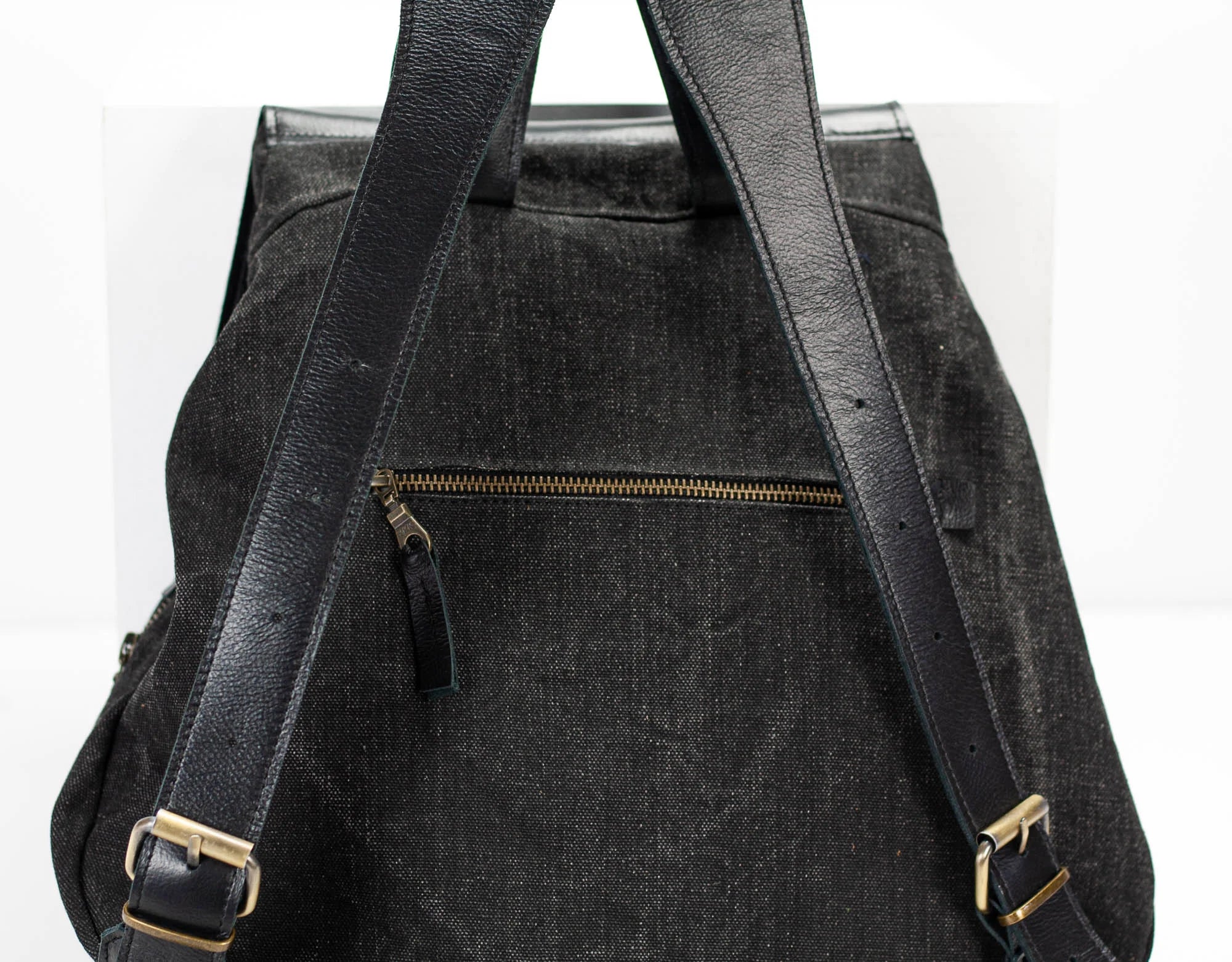 Black backpack with gold zippers and buckles on a white background