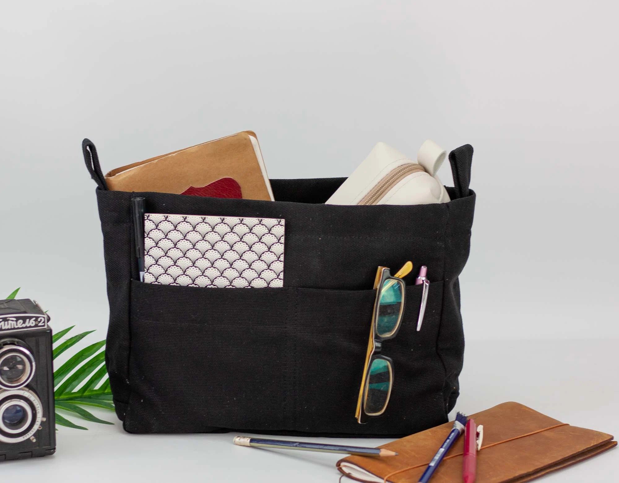 Black cotton bag insert with compartments holding books