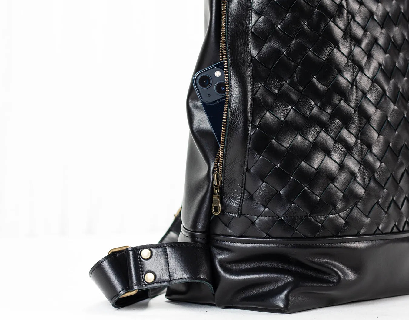Black woven leather bag with a white background
