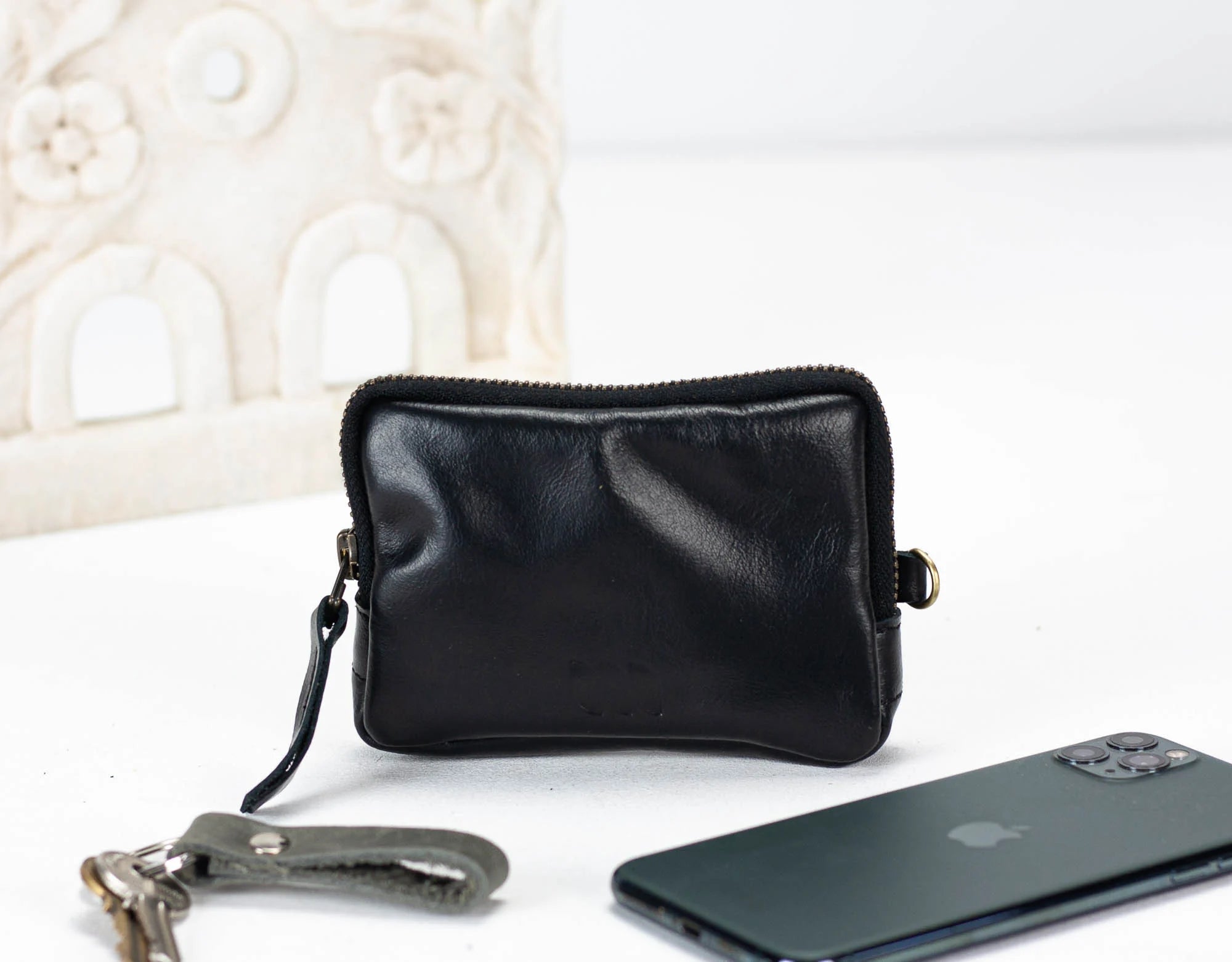 Black leather pouch with keychain and smartphone