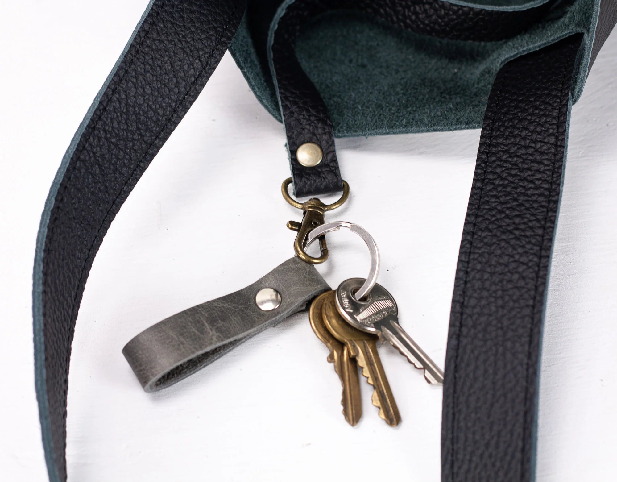 Keychain with keys attached to a dark green bag strap