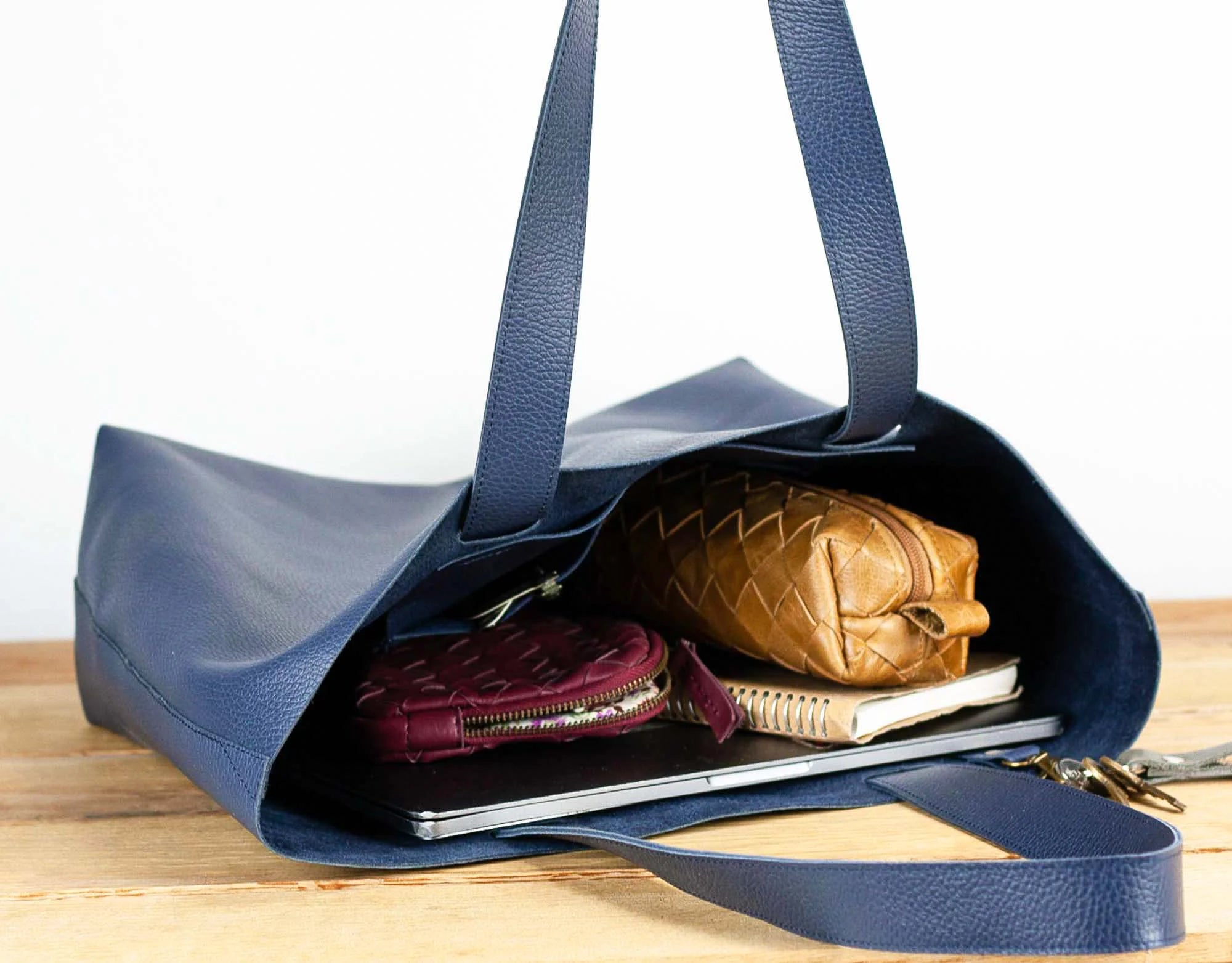 Blue handbag with a brown leather pouch and other items