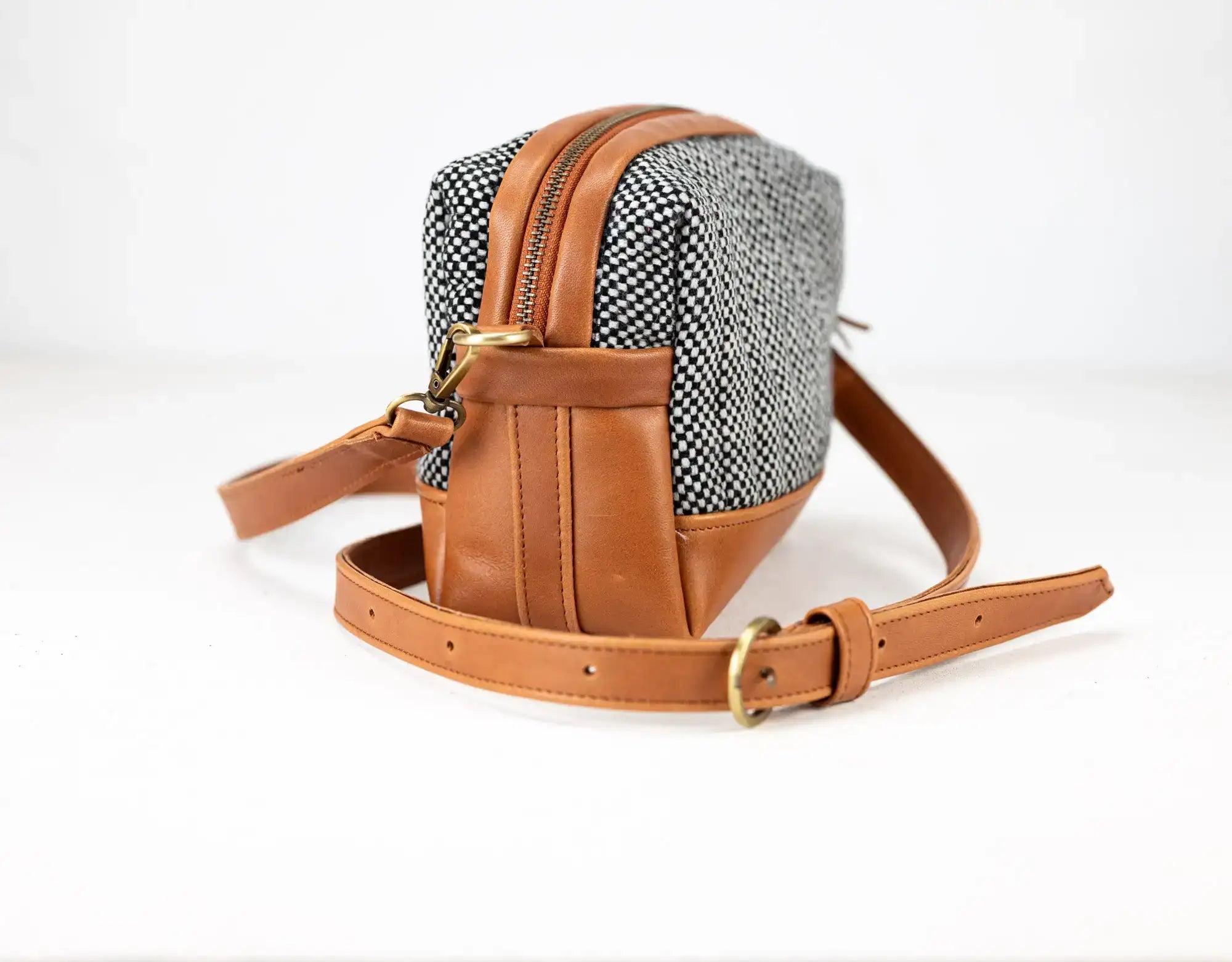 Small backpack with brown leather straps and a patterned fabric front