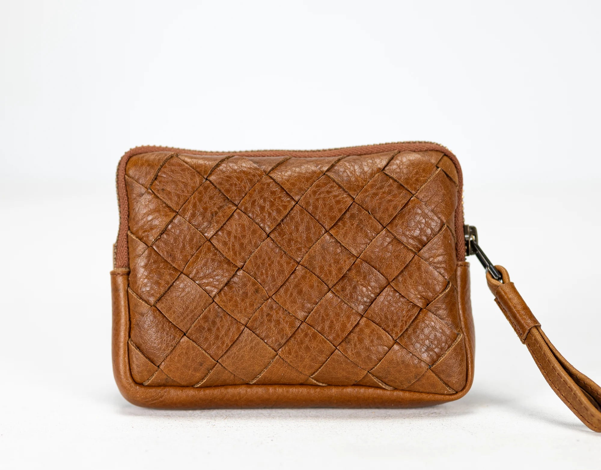 Brown woven leather clutch bag on a white background