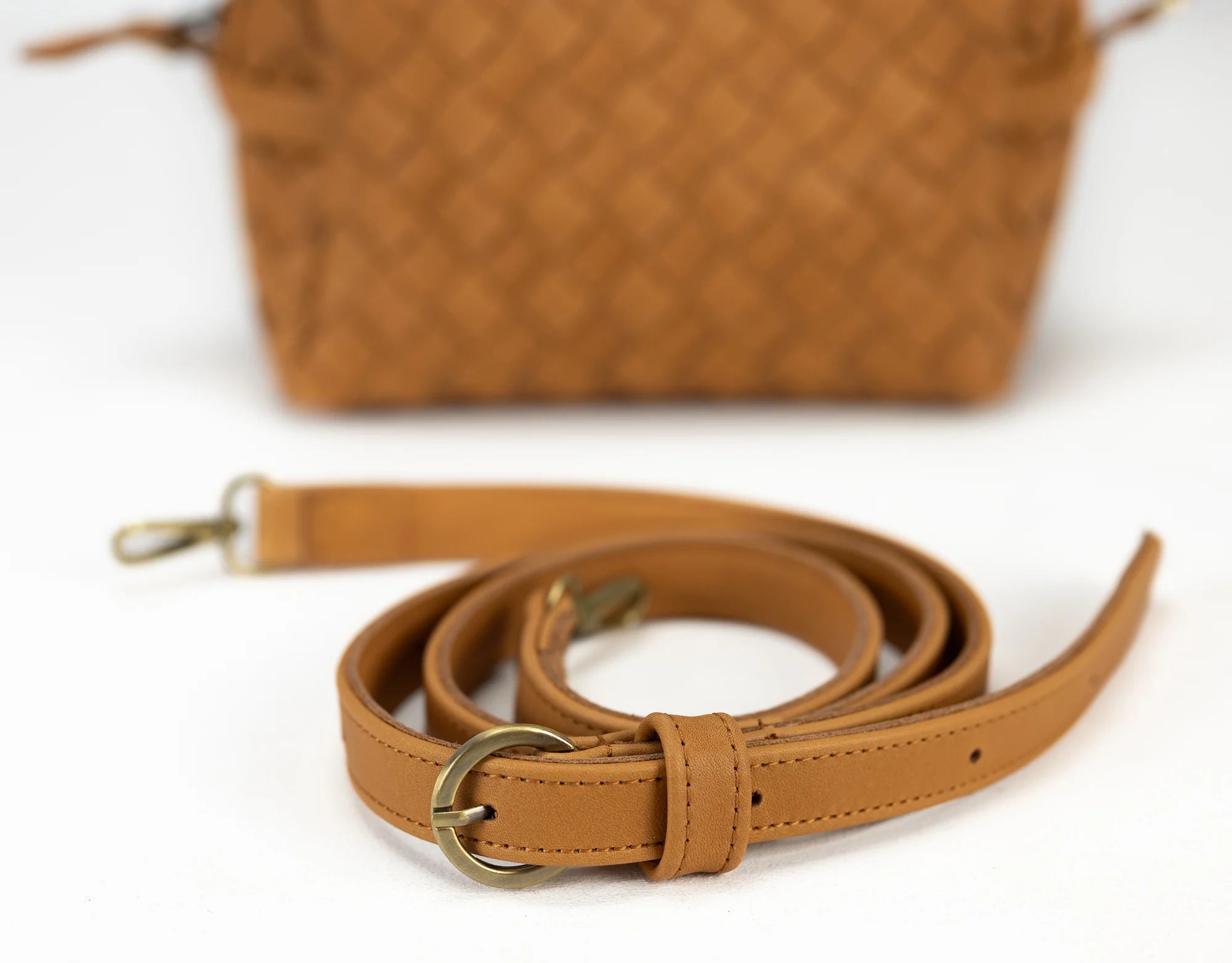 Brown leather strap with gold buckle on a white background