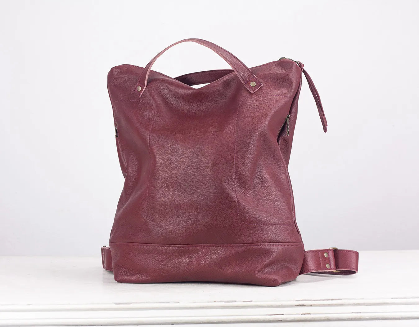 Maroon leather backpack on a white background