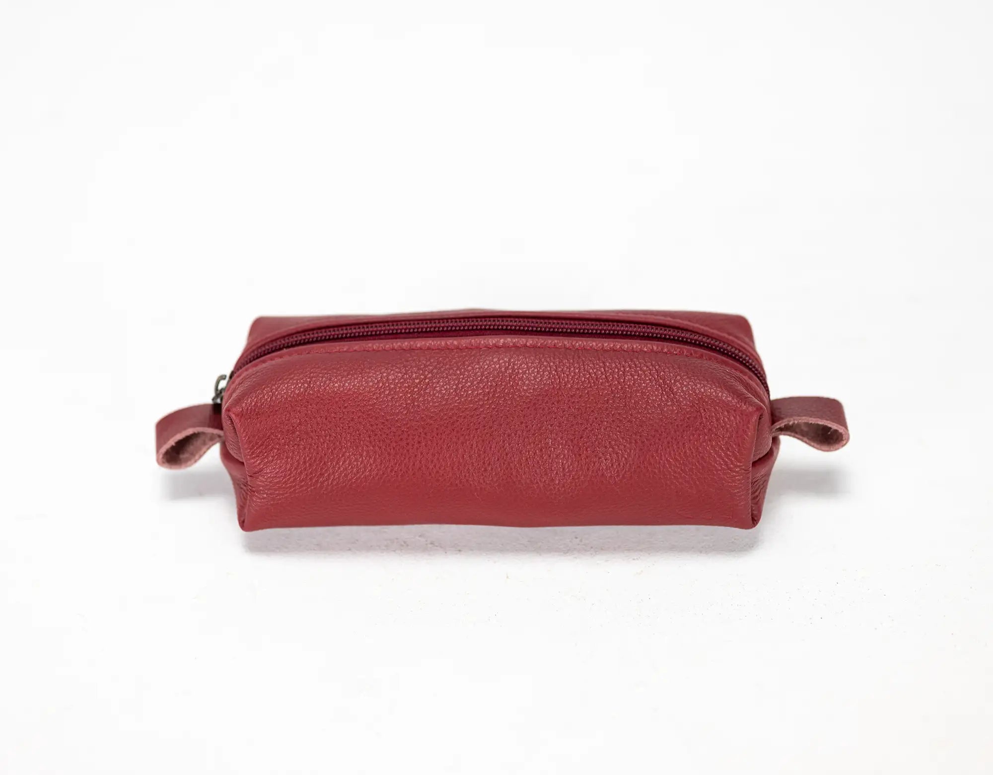 Red leather toiletry bag on a white background