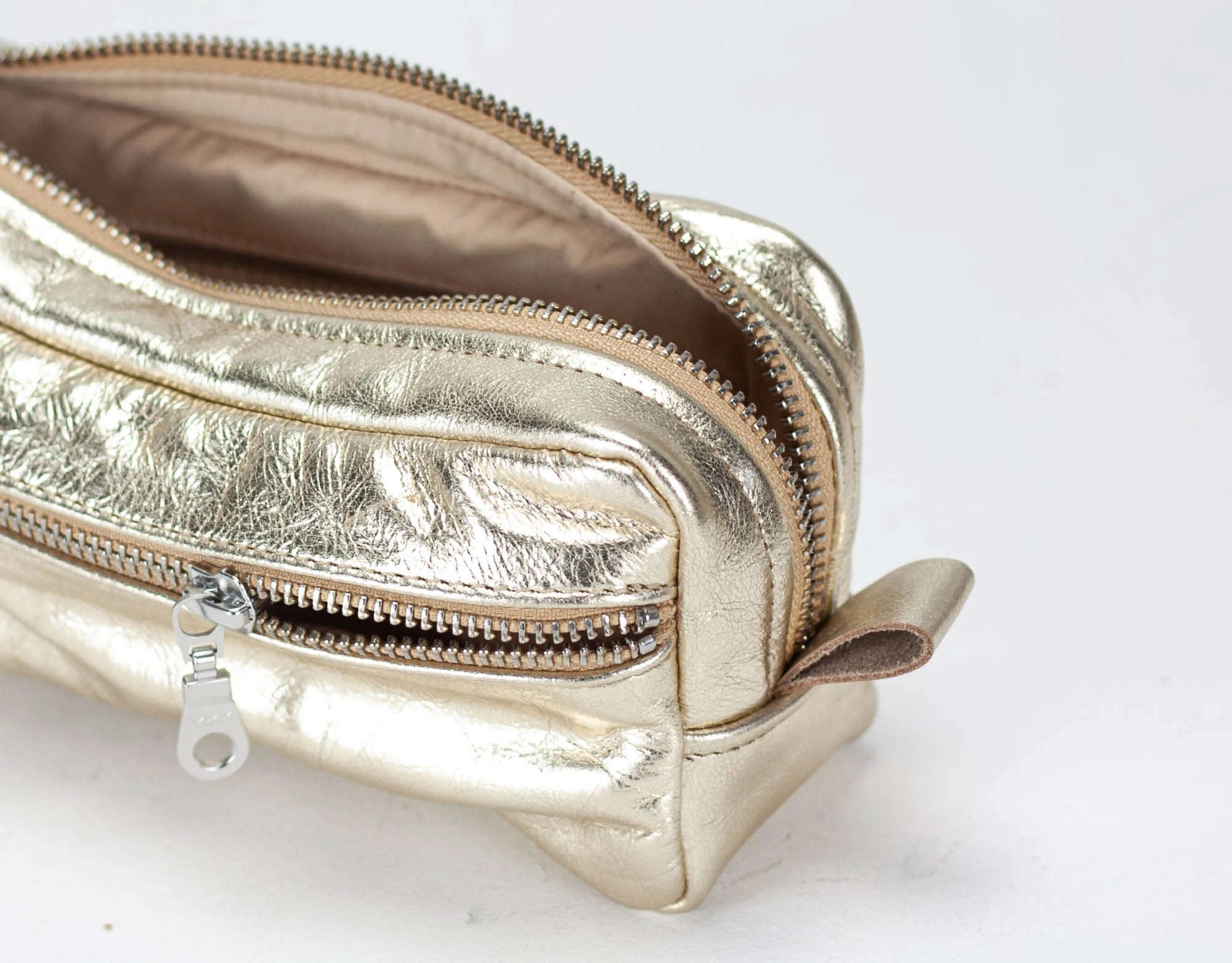 Gold metallic pouch with zipper on a white background