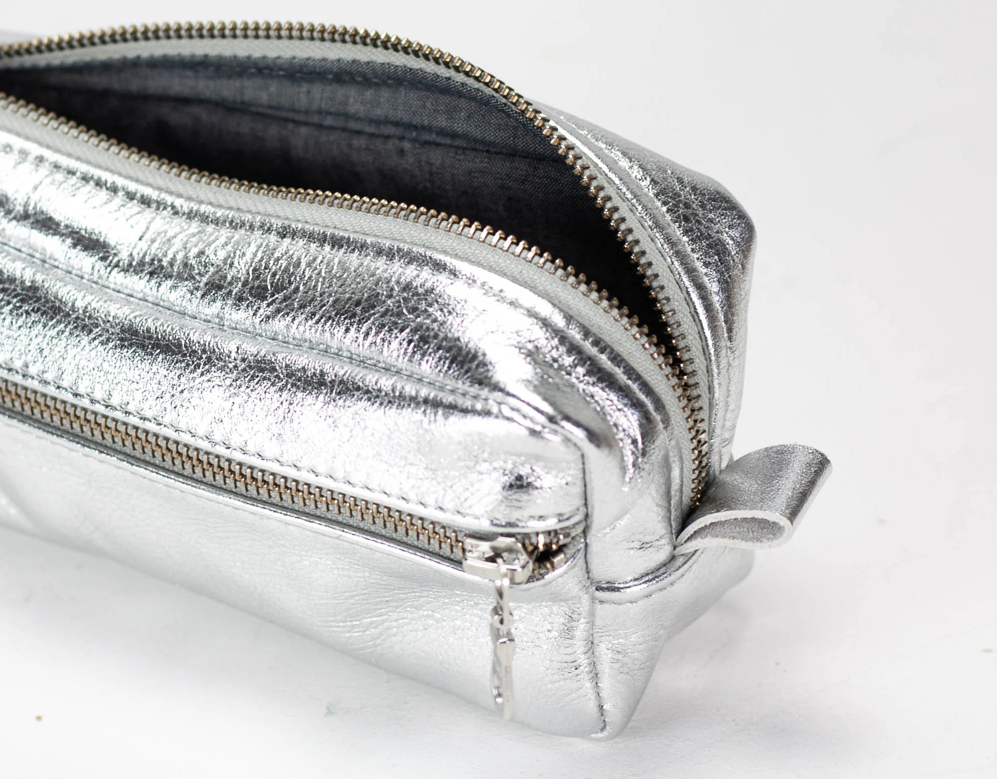 Silver metallic clutch bag on a white background