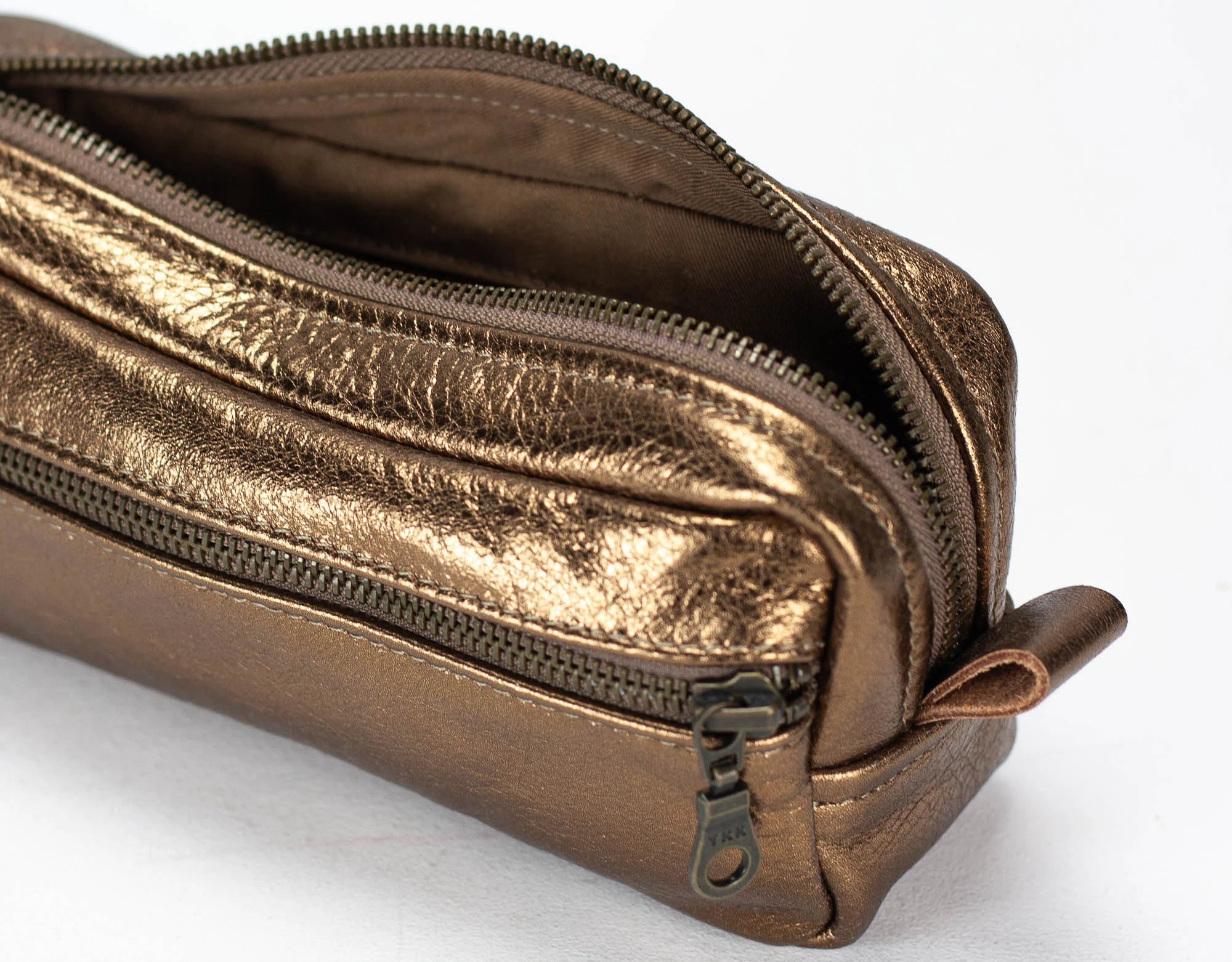 Bronze-colored double-zipper pouch on a white background