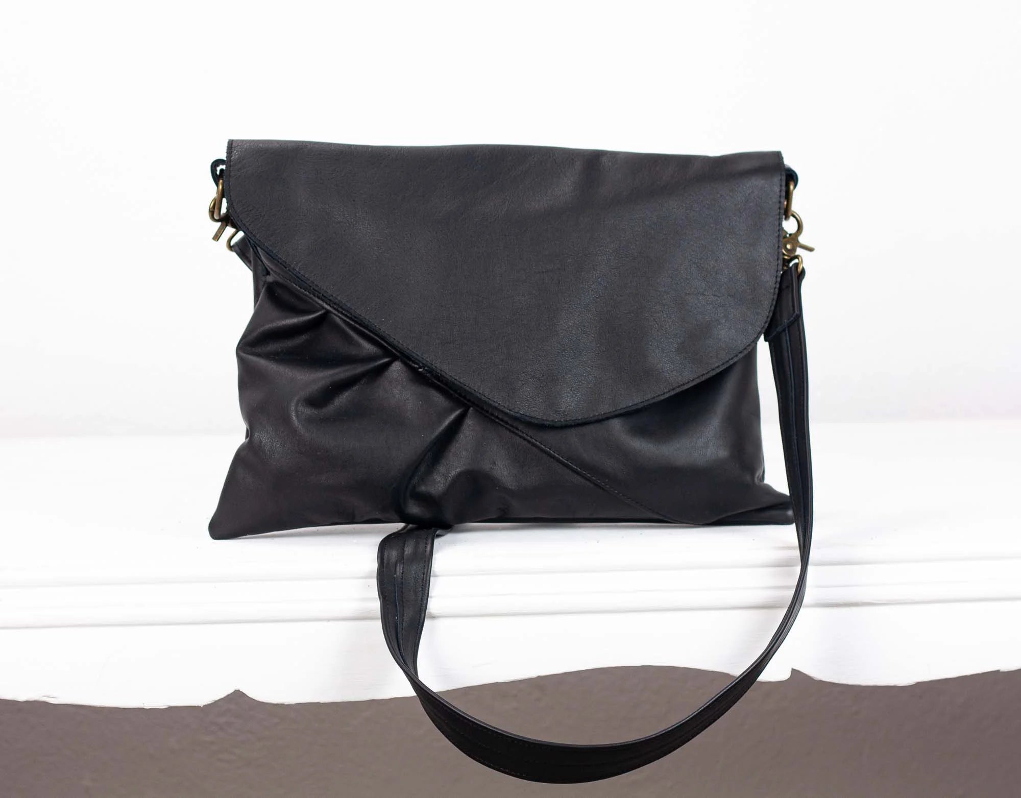 Black leather handbag on a white surface