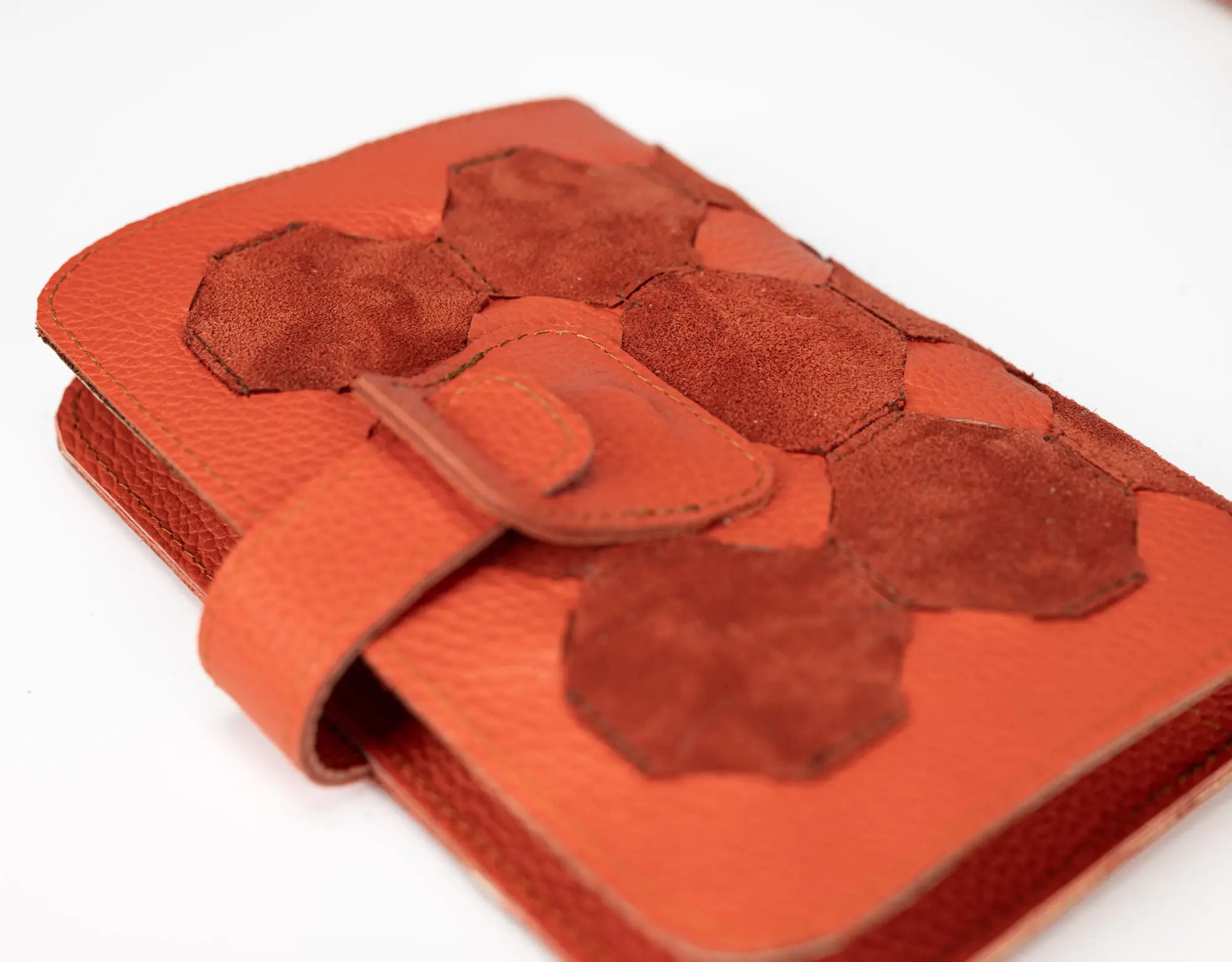Orange leather wallet with hexagonal pattern on a white background