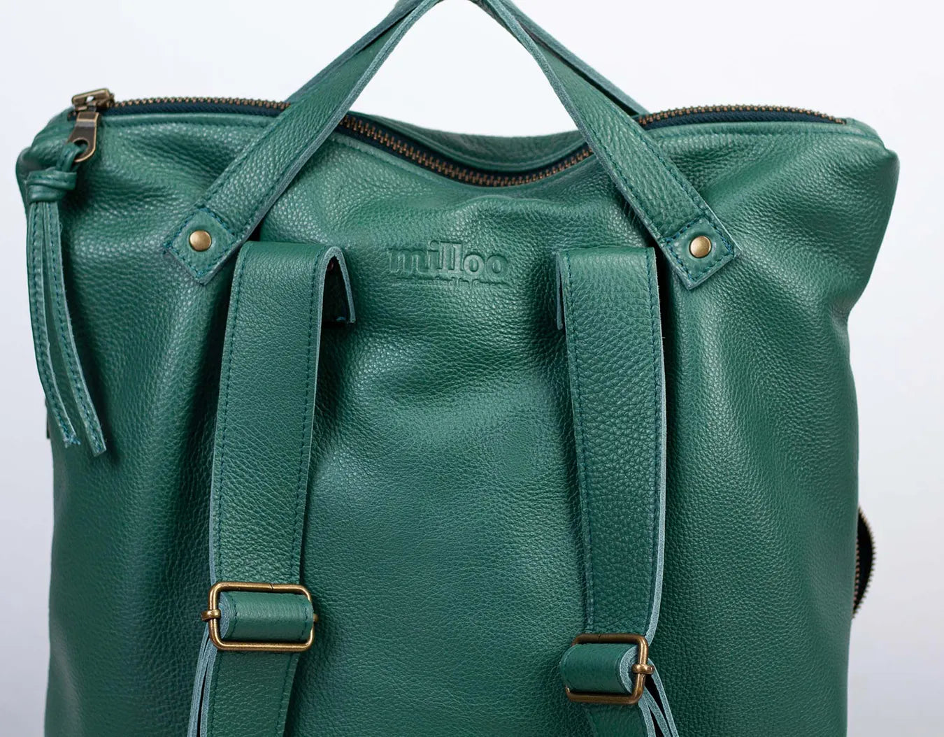 Green leather bag with gold accents on a light gray background