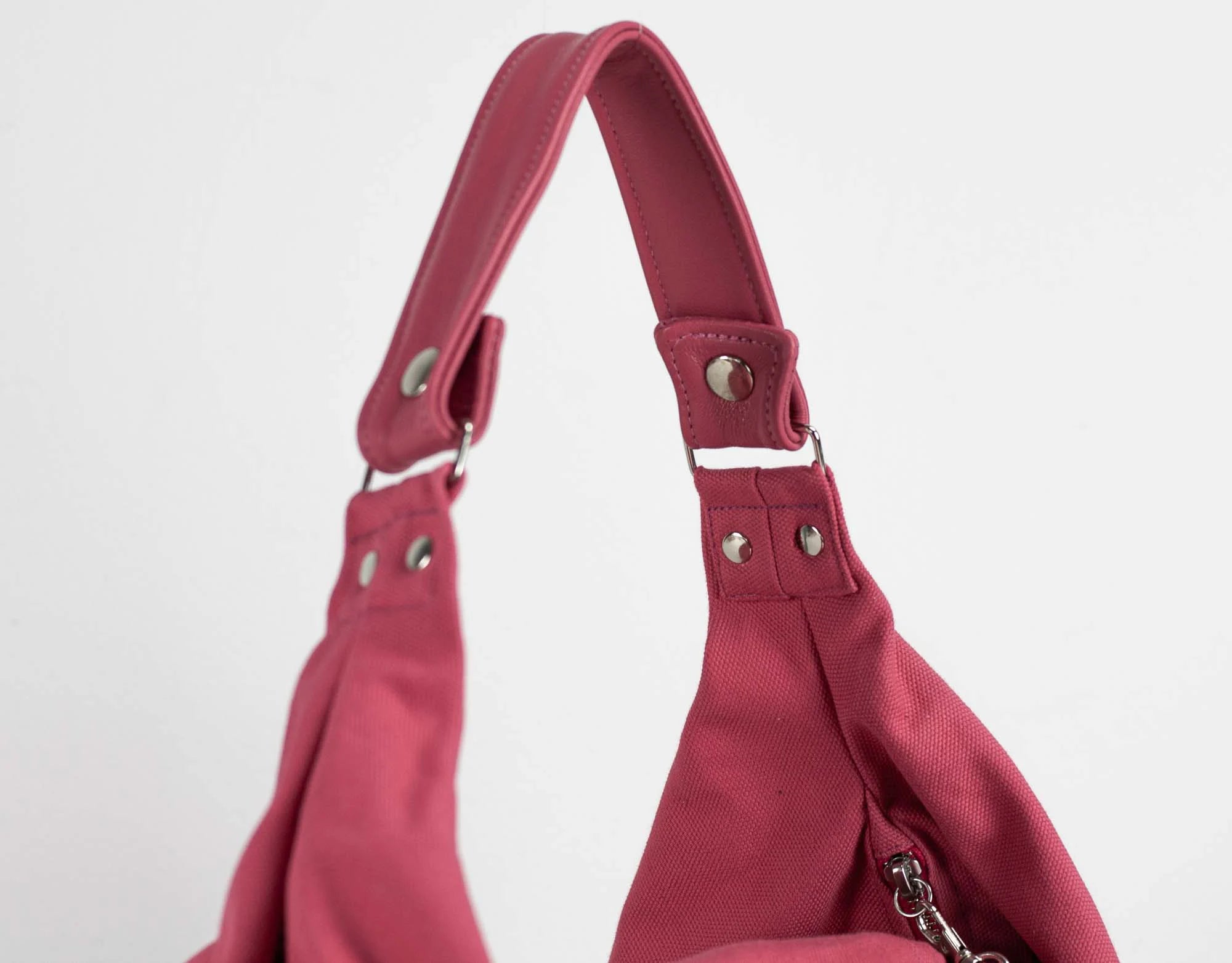 Red handbag with a strap on a light gray background
