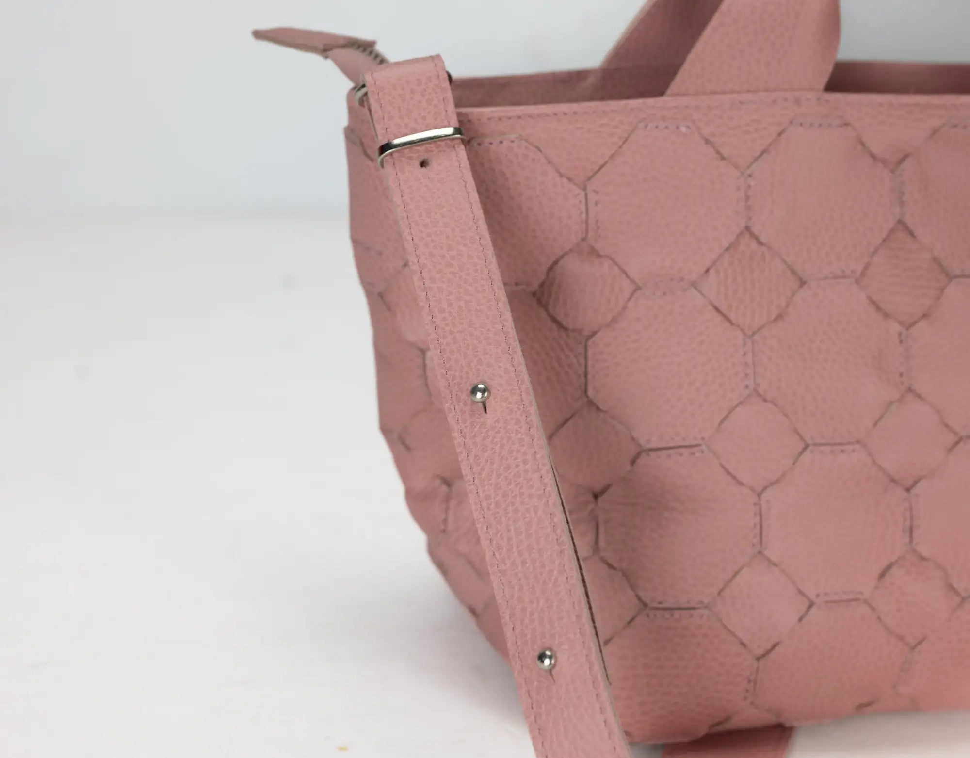 Pink textured handbag on a white background
