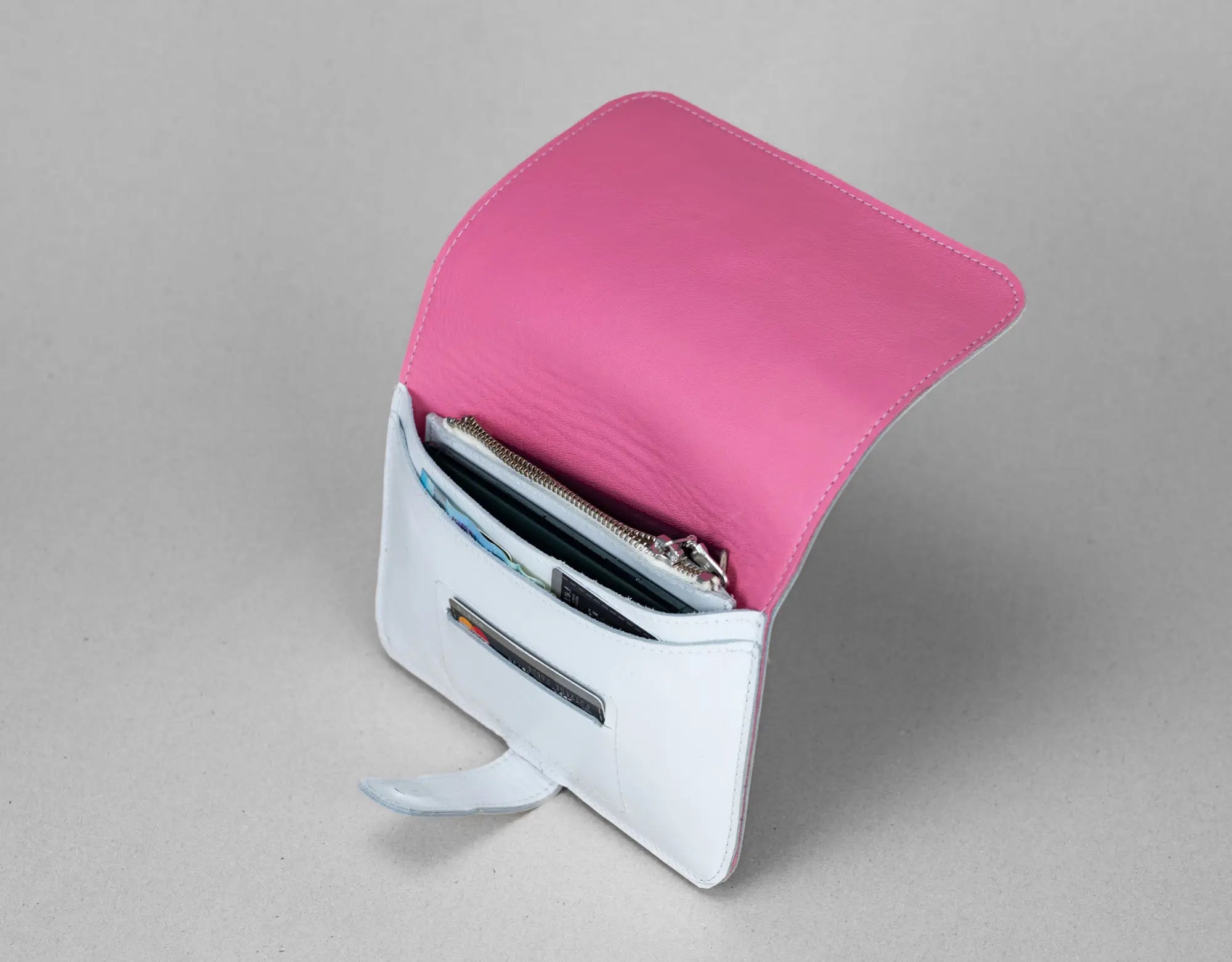 Pink wallet with a metallic stand on a gray background