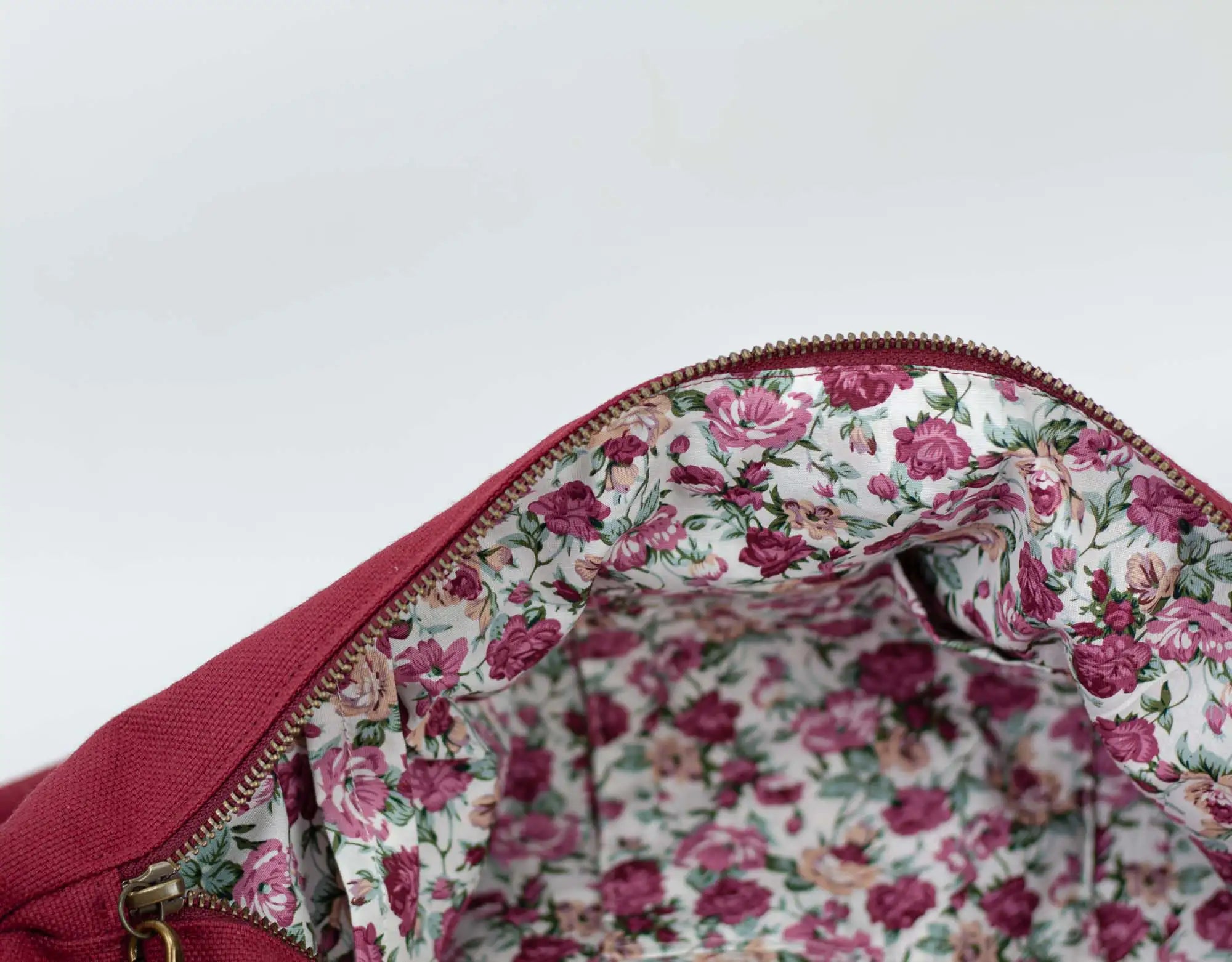 Floral-patterned interior of a red bag on a white background