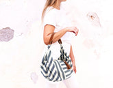 Woman holding a striped bag with a white background
