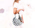 Woman holding a striped bag with a white background
