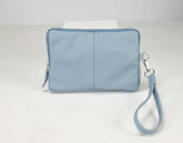 Light blue wristlet bag with a strap on a white background