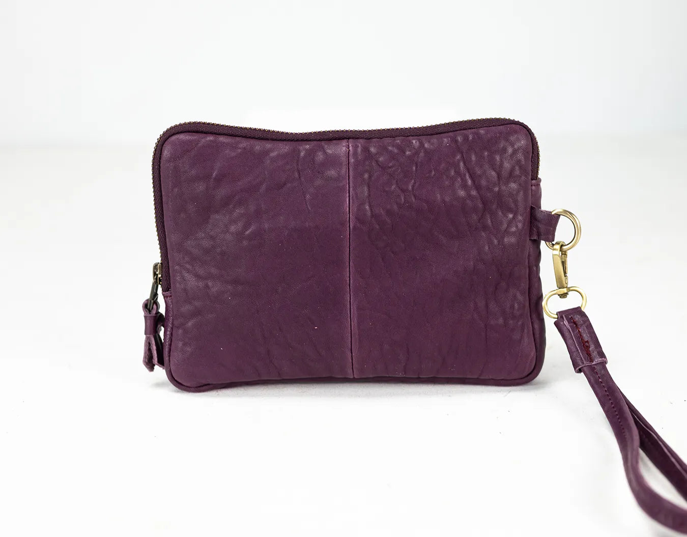 Purple leather clutch bag with a strap on a white background