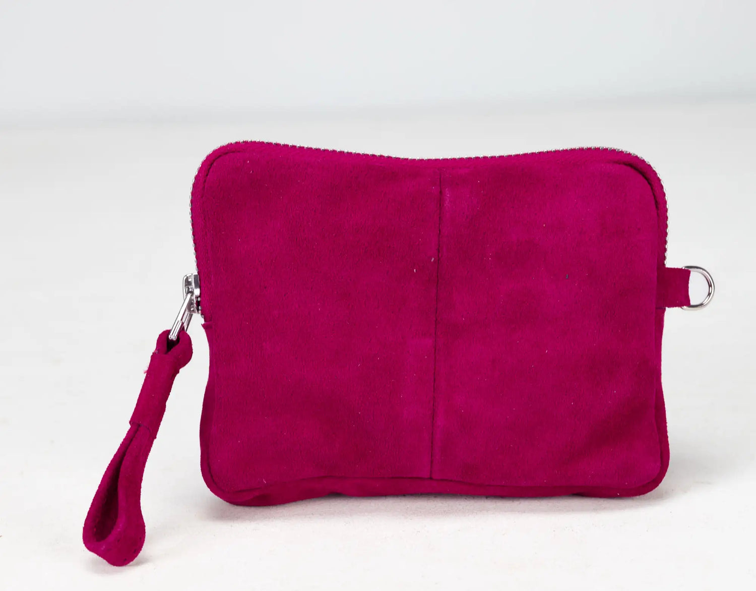 Pink suede pouch with a wrist strap on a white background