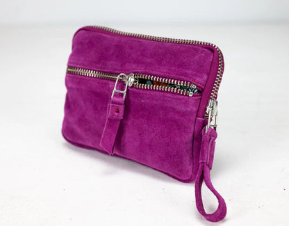 Purple suede clutch bag with a strap on a white background
