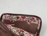 Floral-patterned fabric lining a brown bag on a light gray background