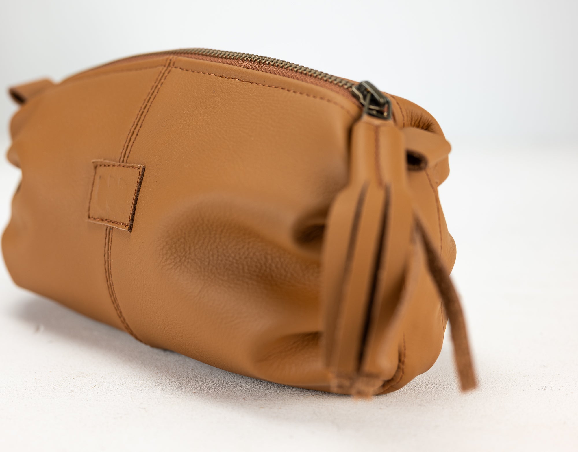 Brown leather pouch with a strap on a white background