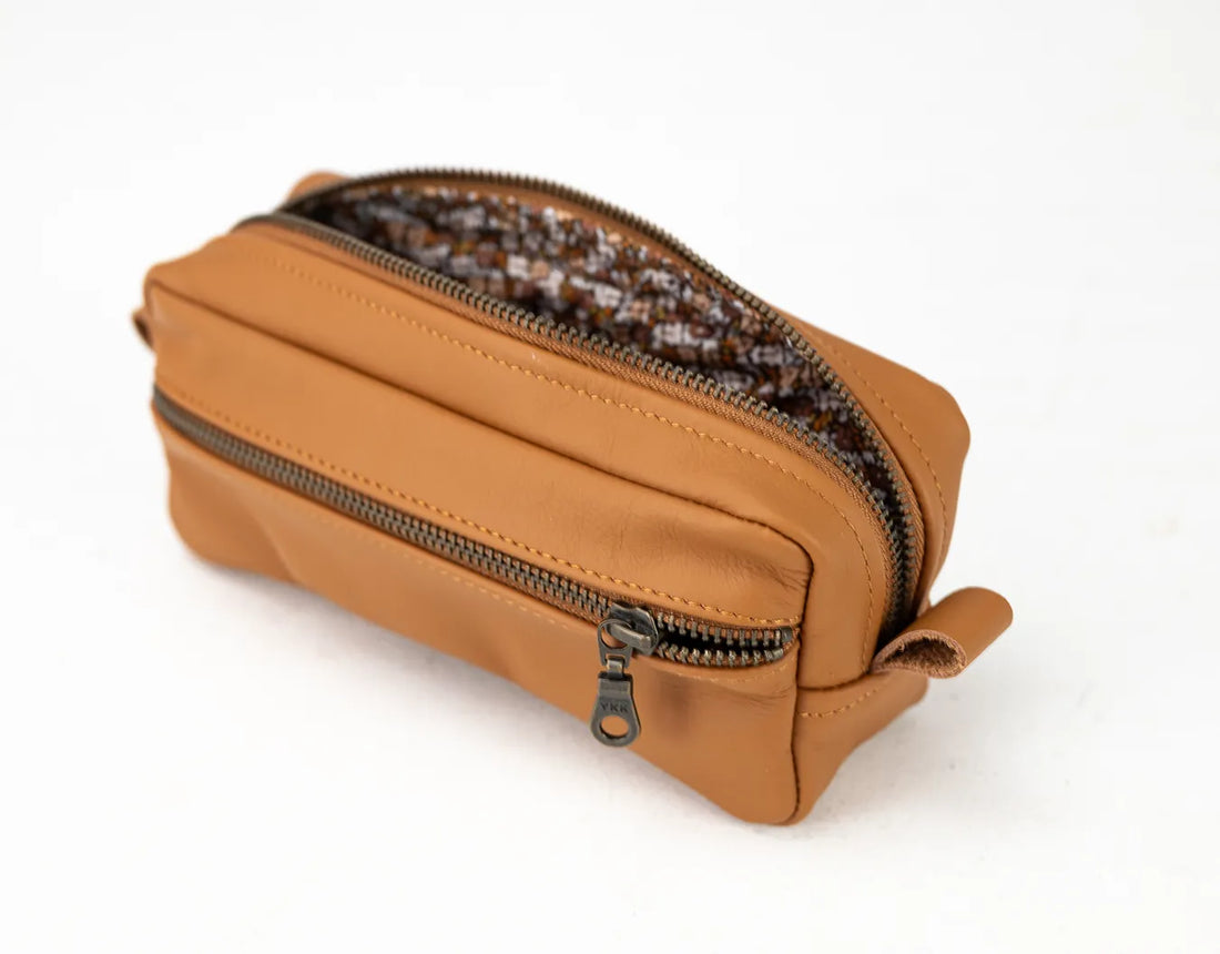Brown leather pouch with zipper on a white background