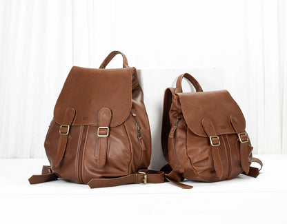 Two brown leather backpacks on a white background