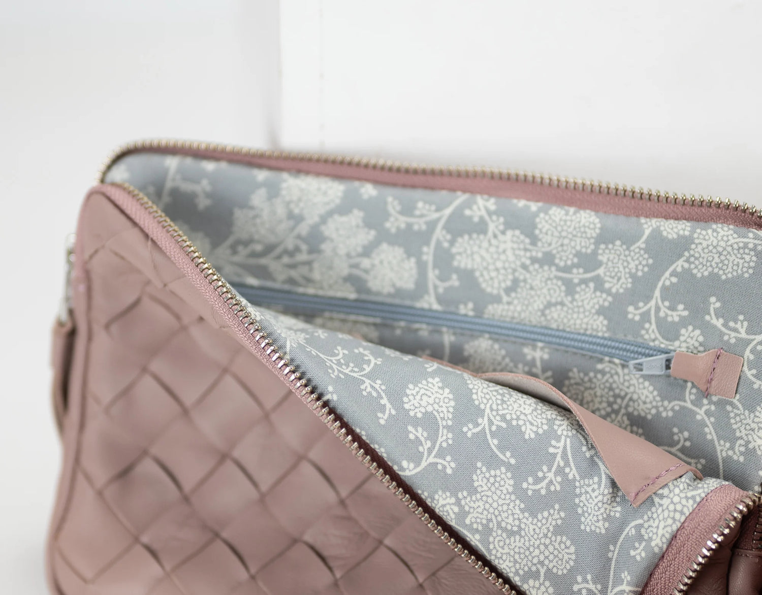 Quilted pink clutch with floral interior on a light background