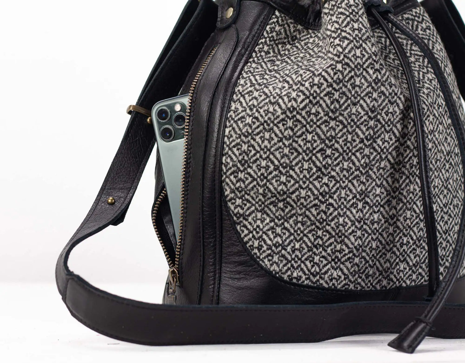 Black and gray patterned backpack with a phone inside on a white background