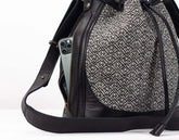 Black and gray patterned backpack with a phone inside on a white background