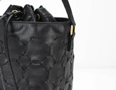 Black textured handbag with a strap on a white background